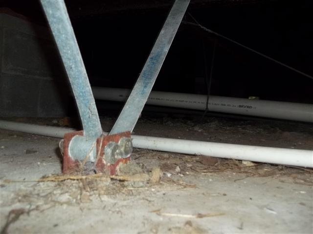 Steel tie-down anchor bracket on a manufactured home foundation